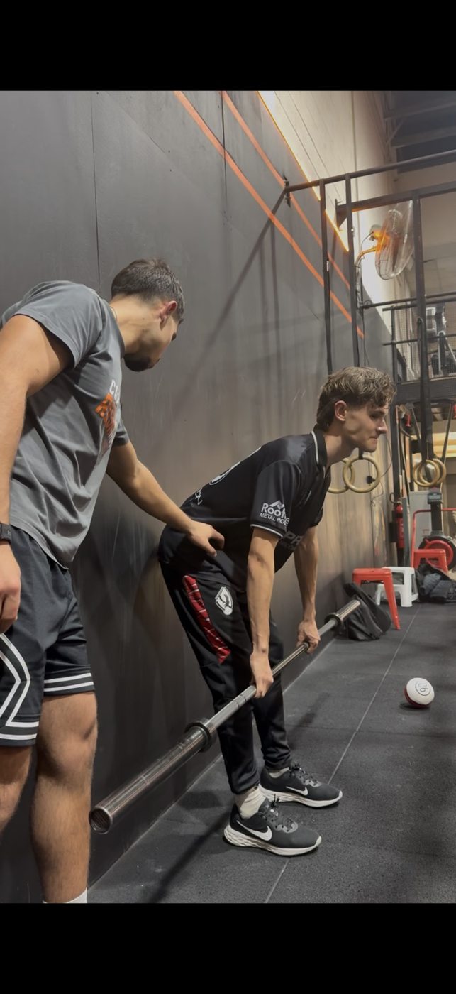 Michel coaching an athlete through a strength exercise